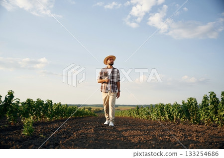 Front view, walking forward. Farmer is on the agricultural field Front view, walking forward. Farmer is on the agricultural field 133254686