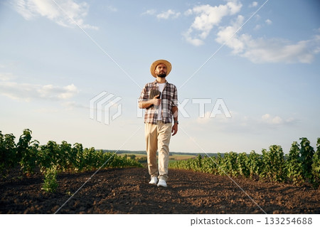Front view, walking forward. Farmer is on the agricultural field Front view, walking forward. Farmer is on the agricultural field 133254688