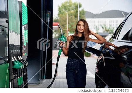 Ready to refill the automobile. A young woman at a gas station with her car Ready to refill the automobile. A young woman at a gas station with her car 133254973