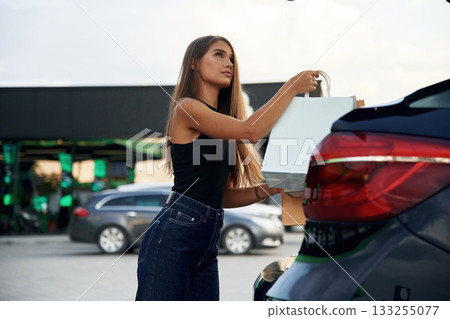 Right after the shopping. Woman is near her car outdoors 133255077