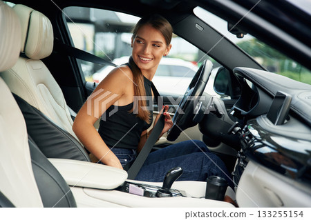 Wearing safety belt. Woman is sitting in the car Wearing safety belt. Woman is sitting in the car 133255154