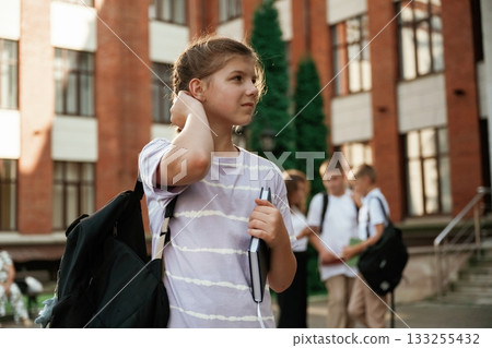 Standing and posing. Kids are near the school together, pupils 133255432