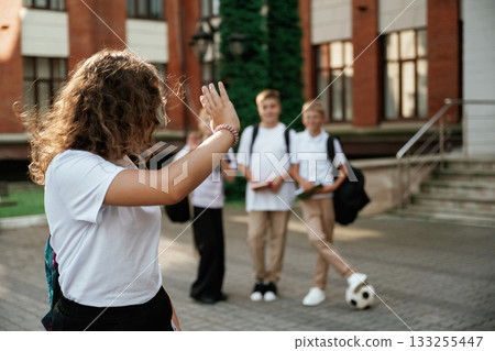 Standing and posing. Kids are near the school together, pupils 133255447