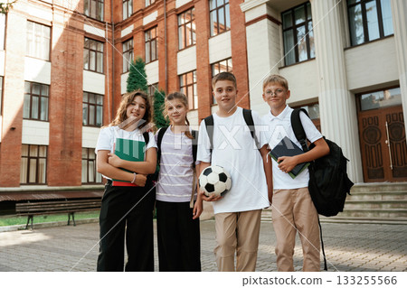 Group of kids are near the school together, pupils Group of kids are near the school together, pupils 133255566
