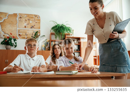 Teacher is at work. Pupils, kids in the classroom together Teacher is at work. Pupils, kids in the classroom together 133255635