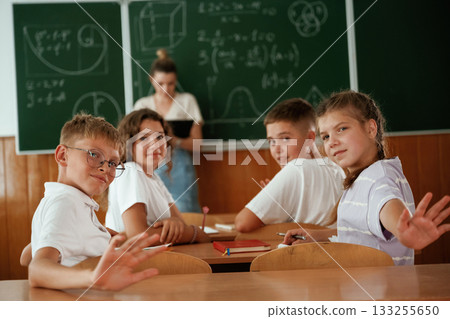 Teacher is at work. Pupils, kids in the classroom together Teacher is at work. Pupils, kids in the classroom together 133255650
