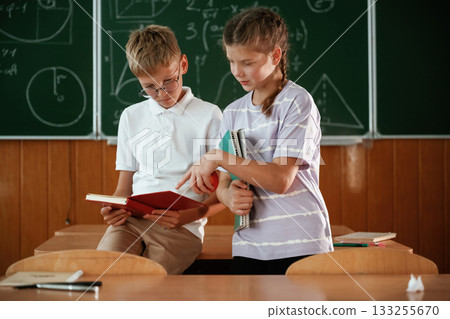 Reading the information that is in the notepad. Pupils, kids in the classroom together 133255670
