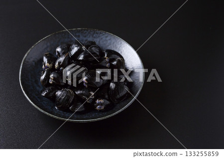 盤子裡盛著大和硨磲，背景是黑色的。 133255859