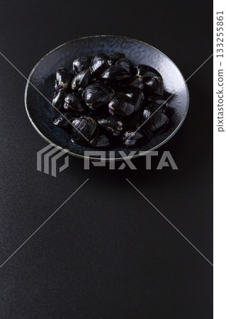 Large Yamato Shijimi clams on a plate against a black background Large Yamato Shijimi clams on a plate against a black background 133255861