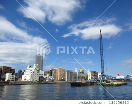 A crane-equipped barge working on the Sumida River A crane-equipped barge working on the Sumida River 133256213