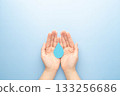 World water day. Hands holding clean water drop symbol on light blue background. Concept of washing hands, CSR, save water and clean renewable energy. 133256686