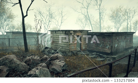 In a serene yet eerie setting, old buildings stand in decay, surrounded by bare trees. A thick mist cloaks the scene, evoking feelings of nostalgia and mystery from a lost era. 133257804