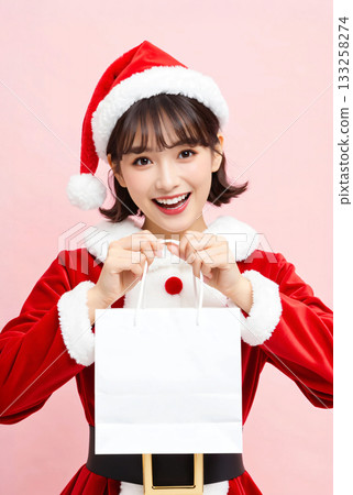 Woman in Santa costume holding a paper bag 133258274