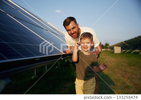 Maintenance of the solar panel. Father with his little son are together Maintenance of the solar panel. Father with his little son are together 133258474