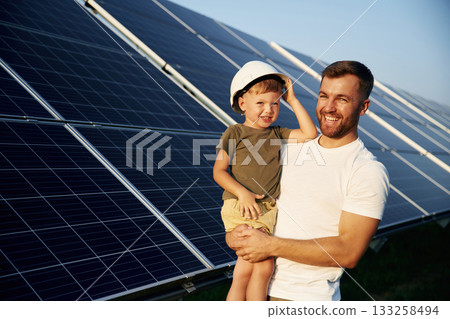 White hard hat. Father with his little son are together near the solar panels 133258494