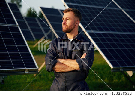 Handsome guy portrait. Man is working with solar panels outdoors at daytime 133258536