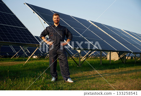 Handsome guy portrait. Man is working with solar panels outdoors at daytime 133258541
