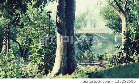 A peaceful park scene showcases vibrant greenery all around. Tall trees and lush bushes frame a winding path, inviting leisurely strolls. 133258590