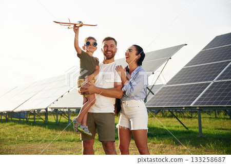 Family is together. Father, mother and little son are outdoors near solar panels 133258687