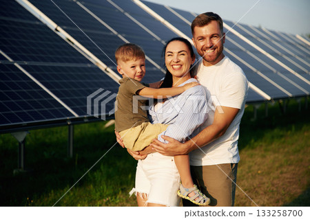 Father, mother and little son are outdoors near solar panels Father, mother and little son are outdoors near solar panels 133258700