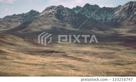 Vast open landscape features towering mountains and a serene valley under a clear sky. The natural beauty and rugged terrain invite exploration and admiration from nature lovers. Vast open landscape features towering mountains and a serene valley under a clear sky. The natural beauty and rugged terrain invite exploration and admiration from nature lovers. 133258747