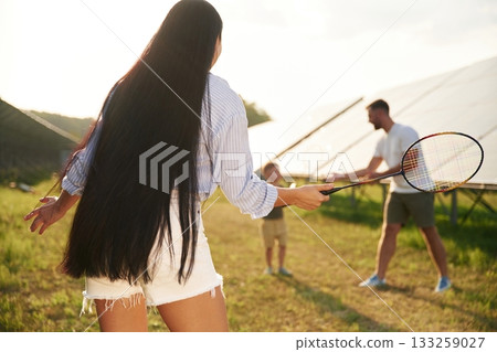 Active weekend, badminton. Father, mother and little son are outdoors near solar panels 133259027