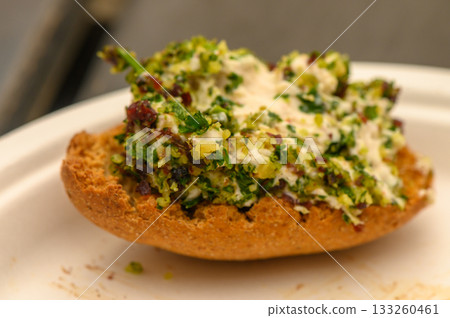 Deliciously crafted bread topped with vibrant green herb mix in an inviting culinary setting Deliciously crafted bread topped with vibrant green herb mix in an inviting culinary setting 133260461