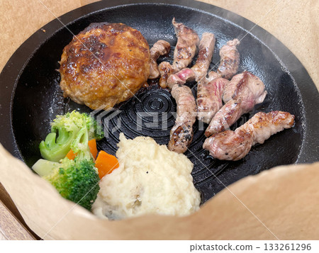 A combination of grilled steak and hamburger patty, a hearty dish overflowing with juicy goodness. A combination of grilled steak and hamburger patty, a hearty dish overflowing with juicy goodness. 133261296