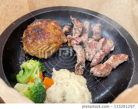 A combination of grilled steak and hamburger patty, a hearty dish overflowing with juicy goodness. A combination of grilled steak and hamburger patty, a hearty dish overflowing with juicy goodness. 133261297
