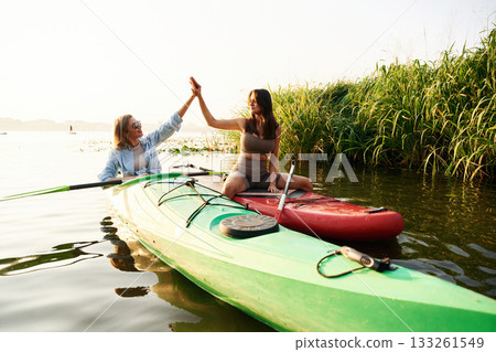 Women friends are on sup board on the lake together 133261549