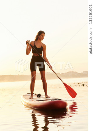 In sport clothes. Young woman is with the sup board on the lake 133261601