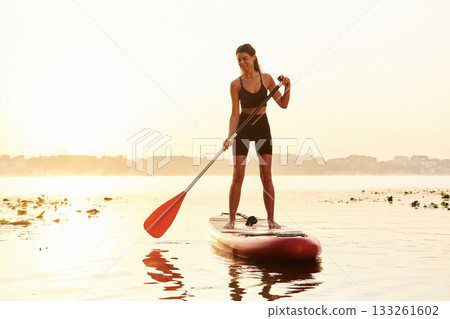 Having a great time by swimming. Young woman is with the sup board on the lake Having a great time by swimming. Young woman is with the sup board on the lake 133261602
