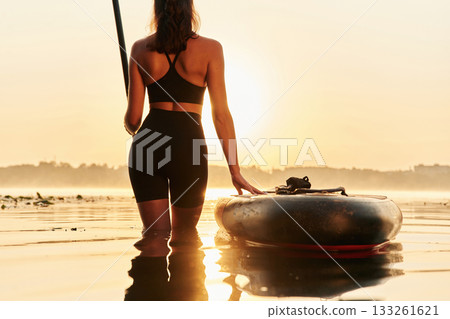 Almost evening time, sunset. Young woman is with the sup board on the lake Almost evening time, sunset. Young woman is with the sup board on the lake 133261621