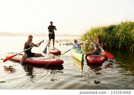 Friends are together on sup boards on the lake Friends are together on sup boards on the lake 133261668