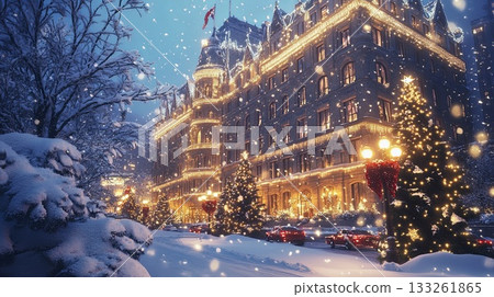 A grand city building lit up for Christmas, surrounded by snow-covered trees and festive decorations . 133261865