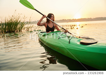 Green colored sup board. Young woman is on the lake 133261908
