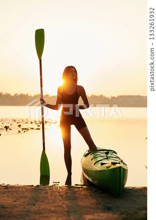 Model is standing and posing. Young woman is with the sup board on the lake Model is standing and posing. Young woman is with the sup board on the lake 133261932