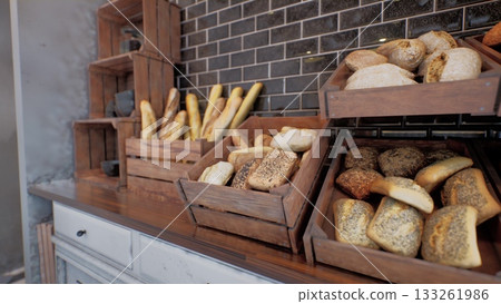 Freshly baked artisan bread fills wooden crates in a quaint bakery, inviting patrons to enjoy the warm, inviting atmosphere. The rustic decor enhances the charm, making it a perfect stop. Freshly baked artisan bread fills wooden crates in a quaint bakery, inviting patrons to enjoy the warm, inviting atmosphere. The rustic decor enhances the charm, making it a perfect stop. 133261986
