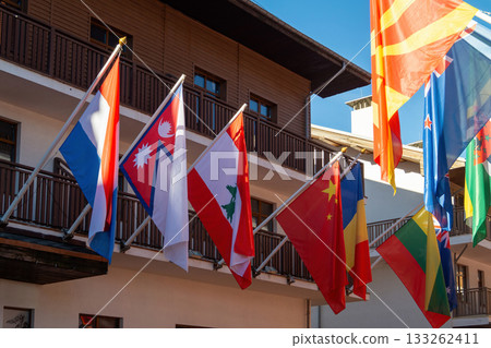 Colorful flags of different nations decorate a building during a sunny day in a vibrant locale Colorful flags of different nations decorate a building during a sunny day in a vibrant locale 133262411