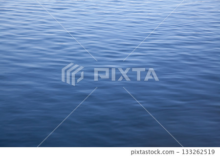 Calm ripples create a serene surface on the river during midday light Calm ripples create a serene surface on the river during midday light 133262519