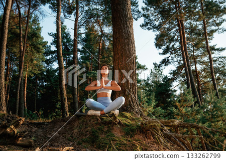 Standard lotus pose. Woman is doing yoga fitness exercises in the forest Standard lotus pose. Woman is doing yoga fitness exercises in the forest 133262799