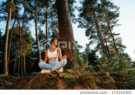 Woman is doing yoga fitness exercises in the forest Woman is doing yoga fitness exercises in the forest 133262802