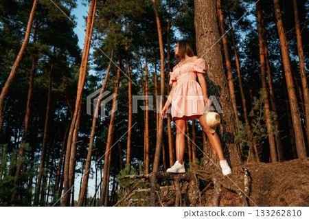 Pretty young woman in pink dress is in the forest Pretty young woman in pink dress is in the forest 133262810