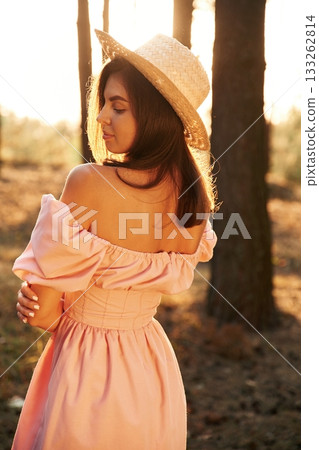 Back, rear view. Pretty young woman in pink dress is in the forest Back, rear view. Pretty young woman in pink dress is in the forest 133262814