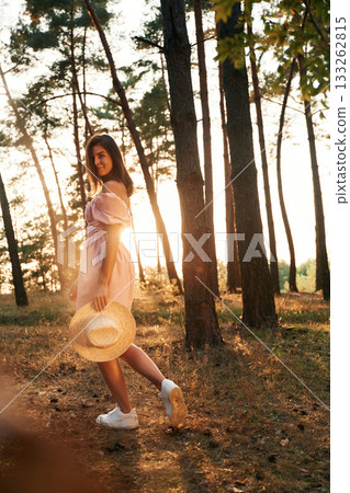 Amazing sunlight. Pretty young woman in pink dress is in the forest Amazing sunlight. Pretty young woman in pink dress is in the forest 133262815