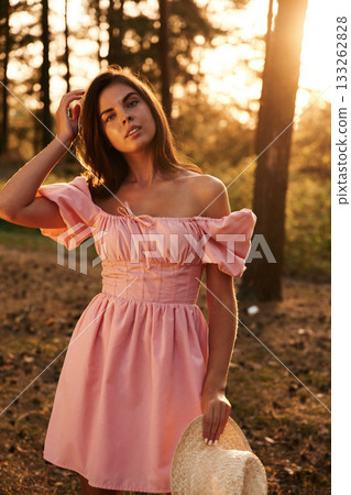 Front view. Pretty young woman in pink dress is in the forest 133262828