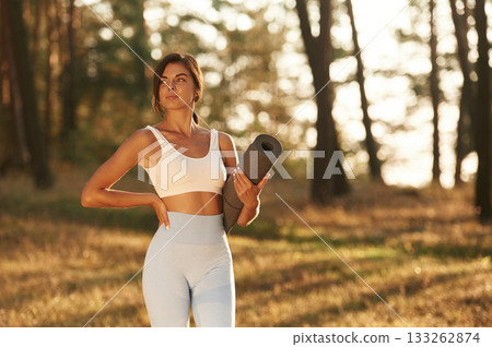 Rural scene. Woman is doing yoga fitness exercises in the forest Rural scene. Woman is doing yoga fitness exercises in the forest 133262874