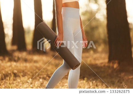 Wellbeing outdoors. Woman is doing yoga fitness exercises in the forest 133262875