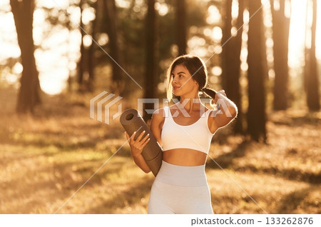 Wellbeing outdoors. Woman is doing yoga fitness exercises in the forest Wellbeing outdoors. Woman is doing yoga fitness exercises in the forest 133262876