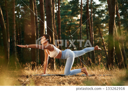 Stretching exercises. Woman is doing yoga fitness exercises in the forest 133262916